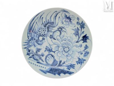 une assiette bleue et blanche ornée d'un oiseau et de fleurs