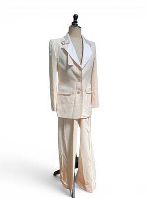 un mannequin vêtu d'un costume blanc, posé sur un socle