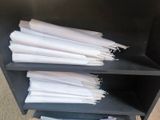 a lot of papers that are stacked on a shelf