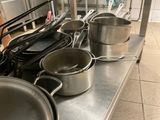 several pots and pans are lined up on a counter in a kitchen