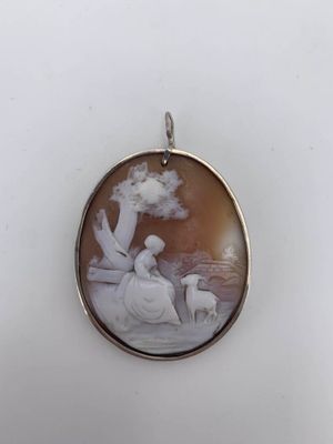 an image of a pendant with a picture of a woman and a dog
