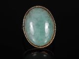 une bague en or sertie d'une pierre de jade verte au centre
