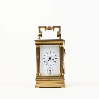 a small clock that is sitting on a white surface