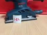 un gros plan d'une ponceuse orbitale Bosch posée sur une table