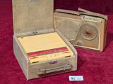 two suitcases and a radio sitting on a red carpet