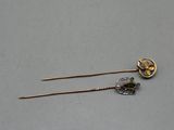 pair of gold and silver hair pins with green stones