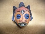 a mask with blue eyes sitting on a gold surface