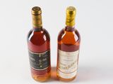 two bottles of liquor sitting next to each other on a white surface