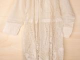 white lace dress hanging on a wooden wall with a wooden hanger