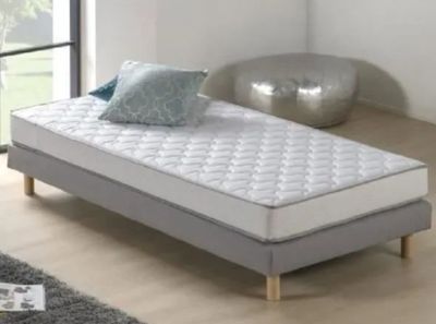 un lit sur lequel est posé un matelas dans une pièce