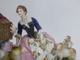 a figurine of a woman and a man with a birdcage
