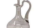 a clear glass bottle with a handle on a white surface