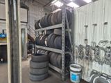 de nombreux pneus empilés sur un support dans un garage