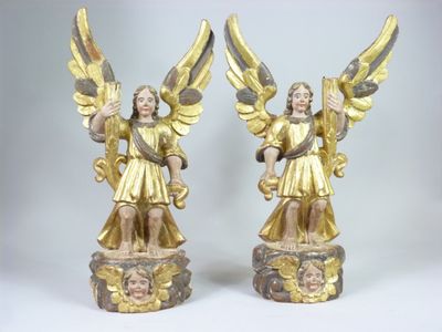 Deux statues d'anges ailés sont posées sur un socle