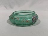 a green glass bowl with a flower design on it