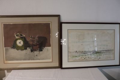 two framed pictures on a table with a clock on it