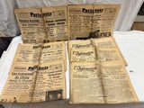 plusieurs vieux journaux posés sur une table recouverte d'une nappe blanche