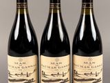 trois bouteilles de vin sont alignées sur une table