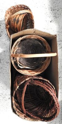 une boîte remplie de paniers contenant de la laine et une brochette en bois