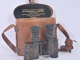 an old pair of binoculars sitting in a case on a white surface