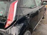 a small black car parked in a parking lot