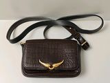 une image représentant un sac à main marron orné d'un oiseau doré
