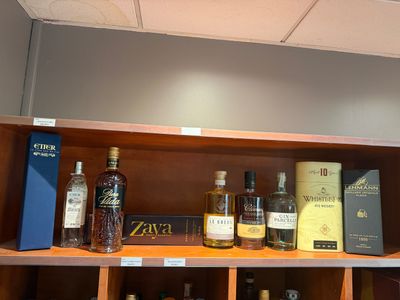 de nombreuses bouteilles d'alcool sur une étagère dans un magasin de spiritueux