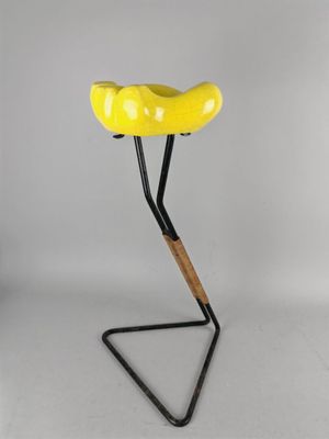 une image représentant un tabouret jaune avec une assise en bois