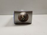 a small metal object with a green button on it