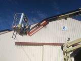 a man on a cherry picker working on the side of a building