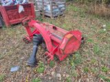 un tracteur rouge assis dans l'herbe