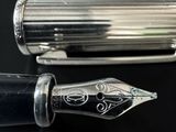 an image of a fountain pen sitting on top of a black table