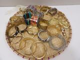 many different types of rings and bracelets on a tray