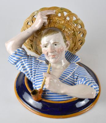 une figurine représentant un homme avec un panier sur la tête