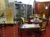 a room with a table, chairs, cabinets, and other items