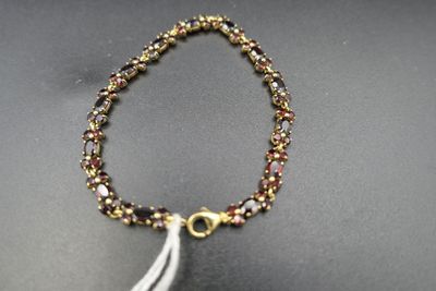 a close up of a bracelet with a tassel on a table
