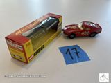une petite voiture rouge posée à côté d'une boîte remplie de chiffres