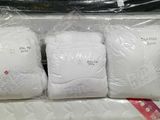 three bags of white pillows on top of each other