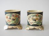 two cups that are decorated with birds and flowers
