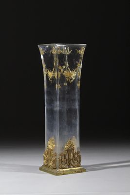 un vase en verre orné de motifs dorés, posé sur une table