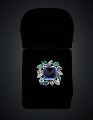 a blue sapphire and diamond ring in a black velvet box