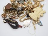 a pile of assorted jewelry on a white surface