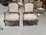 une paire de chaises anciennes à accoudoirs rembourrés dans un magasin
