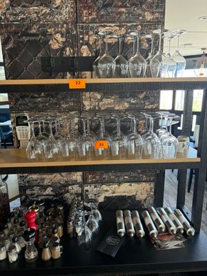 une étagère sur laquelle sont posés des verres à vin et des bouteilles