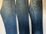 trois paires de jeans Levi's suspendues à un portant