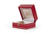 a red box with a gold ring inside of it