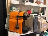 une machine à café orange posée sur une étagère dans une cuisine