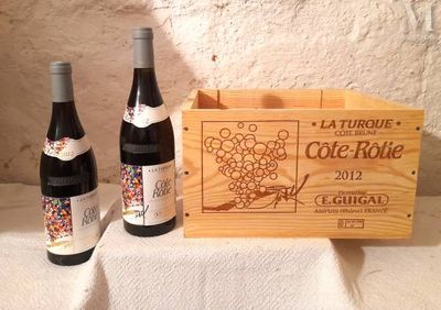 trois bouteilles de vin dans un coffret en bois sur une table