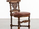 une chaise ancienne en bois, avec une assise en cuir marron et des pieds en bois