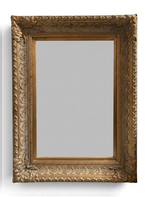 un miroir à cadre doré accroché à un mur blanc, à côté d'un mur